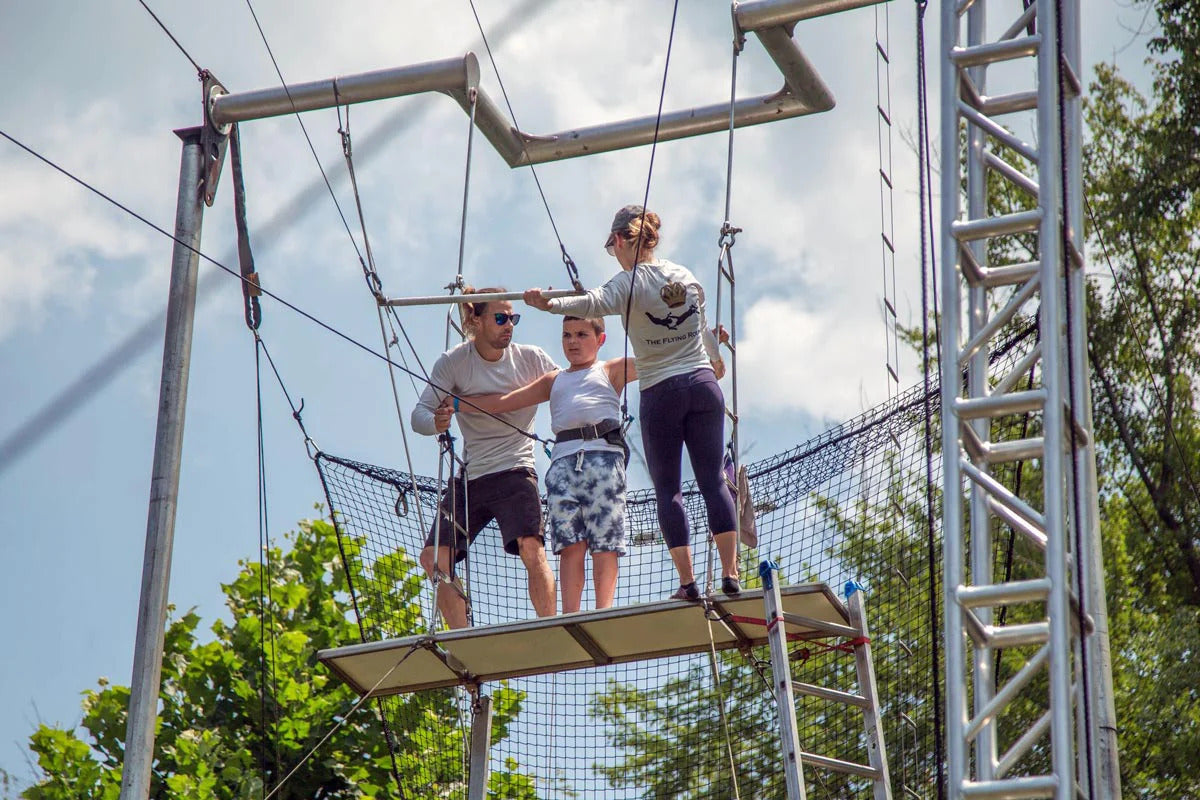 Flying Royals team members supervising a young participant on the platform